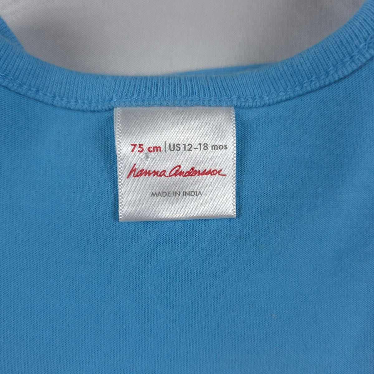 Bushel & Peck Children's Consignment Boutique Hanna Andersson dress size 12-18 months label on blue cotton fabric